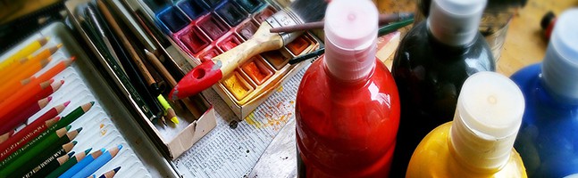 paints, paintbrushes and pencils representing a creative team building workshop
